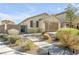 Charming single-story home with desert landscaping, a paved walkway, and a well-manicured lawn at 6318 Amber Sunrise St, North Las Vegas, NV 89031