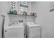 Well-lit laundry room with modern washer and dryer units and decorative shelving above at 6318 Amber Sunrise St, North Las Vegas, NV 89031