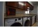 Kitchen featuring granite counters, tile backsplash, dark cabinets, modern appliances, and washer/dryer at 634 Oakmont Ave # 1903, Las Vegas, NV 89109