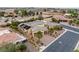 Gorgeous aerial view of desert home with solar panels, mature landscaping, tile roof, circular driveway, and an attached garage at 7504 Frittata Ave, Las Vegas, NV 89113