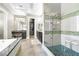 Luxurious bathroom featuring a glass enclosed shower with a built-in seat and double vanity at 7504 Frittata Ave, Las Vegas, NV 89113