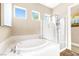 Bright bathroom featuring a soaking tub, glass shower and natural light from multiple windows at 7504 Frittata Ave, Las Vegas, NV 89113