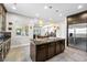 Stylish kitchen with granite countertops, center island with breakfast bar, and stainless fridge at 7504 Frittata Ave, Las Vegas, NV 89113