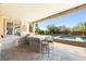 Outdoor kitchen with seating, offering a great view of the pool and backyard at 7504 Frittata Ave, Las Vegas, NV 89113