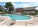 Kidney-shaped community pool surrounded by lounge chairs and lush green spaces at 753 Oakmont Ave # 802, Las Vegas, NV 89109