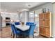Modern kitchen and dining area with stainless steel appliances and stylish blue chairs around a white table at 831 E Galingale Ct, Henderson, NV 89015