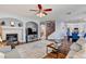 Open-concept living room with a fireplace, ceiling fan, and seamless flow into the dining and kitchen areas at 831 E Galingale Ct, Henderson, NV 89015