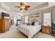 Spacious primary bedroom with a tray ceiling, ceiling fan and multiple windows providing lots of light at 831 E Galingale Ct, Henderson, NV 89015