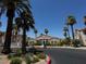A view of the community clubhouse surrounded by beautiful palms and a landscaped roundabout at 855 N Stephanie St # 2311, Henderson, NV 89014
