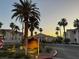 Community street view with lush landscaping and palms at sunset at 855 N Stephanie St # 2311, Henderson, NV 89014