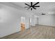 Spacious bedroom with hardwood floors, fan, and adjacent bathroom, enhanced by natural light and an open layout at 8789 Villa Alex Ave, Las Vegas, NV 89147