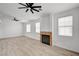 Bright living room with hardwood floors, a ceiling fan, and a cozy fireplace, creating an inviting and comfortable atmosphere at 8789 Villa Alex Ave, Las Vegas, NV 89147