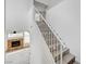 Ascending staircase with white railings, wood stairs, and a glimpse of the living room's fireplace and large windows at 8789 Villa Alex Ave, Las Vegas, NV 89147