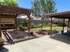 A backyard showcasing a covered patio, pergola with outdoor seating, and landscaped garden at 903 Billings St, Henderson, NV 89002