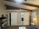 Bedroom with barn-style doors to closets and bathroom, complemented by beamed ceilings at 903 Billings St, Henderson, NV 89002