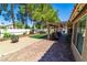 Expansive backyard featuring a covered patio, a fire pit, artificial grass, and a storage shed at 906 Sitting Bull Dr, Henderson, NV 89014