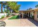 An inviting backyard featuring a covered patio, artificial grass, and low-maintenance landscaping at 906 Sitting Bull Dr, Henderson, NV 89014