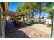 An extended backyard view with patio, artificial grass, garden, and covered patio at 906 Sitting Bull Dr, Henderson, NV 89014