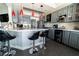Updated kitchen with stainless appliances, breakfast bar with red pendant lights, and sleek gray cabinetry at 906 Sitting Bull Dr, Henderson, NV 89014
