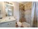 Well-lit bathroom featuring a vanity with a mirror, toilet, and tiled shower with a shower curtain at 908 N 24Th St, Las Vegas, NV 89101
