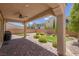 Cozy covered patio and landscaped backyard with artificial turf, gravel, and stone pavers at 9643 Wildflower Vista Ave, Las Vegas, NV 89166