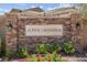Elegant stone community sign with decorative lanterns and colorful flowers at 9643 Wildflower Vista Ave, Las Vegas, NV 89166