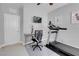 Cozy exercise room with a treadmill, desk with a TV, and ring light setup at 9643 Wildflower Vista Ave, Las Vegas, NV 89166