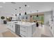 Bright kitchen featuring a large island, white cabinetry, and views of the backyard at 9643 Wildflower Vista Ave, Las Vegas, NV 89166