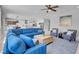 Spacious living room featuring a blue sectional, accent chairs, and an open layout to the kitchen at 9643 Wildflower Vista Ave, Las Vegas, NV 89166