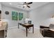 Home office with a large window, a desk, a leather chair, and a ceiling fan at 9643 Wildflower Vista Ave, Las Vegas, NV 89166