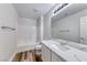 Well-lit bathroom with single vanity, large mirror, and shower-tub combo at 9766 Marcelline Ave, Las Vegas, NV 89148