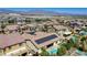 Aerial view showcasing a neighborhood with tile roofs, solar panels, pools, and mountain views in the distance at 9779 Mosaic Canyon Ct, Las Vegas, NV 89149