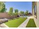 Lush backyard featuring artificial turf, in-ground pool, and brick perimeter wall at 9779 Mosaic Canyon Ct, Las Vegas, NV 89149