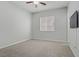 Neutral bedroom with carpet, ceiling fan, window, and wall-mounted television at 9779 Mosaic Canyon Ct, Las Vegas, NV 89149