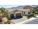 Charming single-story home with a two-car garage, manicured landscaping, and a welcoming front entrance at 9779 Mosaic Canyon Ct, Las Vegas, NV 89149