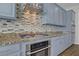 Well-equipped kitchen featuring stainless steel appliances, granite countertops, and a stylish backsplash at 9779 Mosaic Canyon Ct, Las Vegas, NV 89149