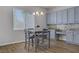 Eat-in kitchen features a dining table, window, and blue cabinets with tile backsplash at 9779 Mosaic Canyon Ct, Las Vegas, NV 89149