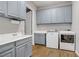 Well-organized laundry room featuring wood-look tile, washer, dryer, and ample cabinet space at 9779 Mosaic Canyon Ct, Las Vegas, NV 89149