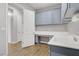 Bright laundry room with desk, sink, washer, and plentiful cabinet storage at 9779 Mosaic Canyon Ct, Las Vegas, NV 89149