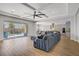 A spacious living room with recessed lighting, hardwood floors, and a large sectional sofa near a glass patio door at 9779 Mosaic Canyon Ct, Las Vegas, NV 89149