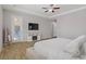 Inviting main bedroom with tv, fireplace, wood-look floors, and patio access at 9779 Mosaic Canyon Ct, Las Vegas, NV 89149