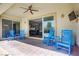 Cozy covered patio with comfortable blue rocking chairs, offering a relaxing outdoor space with access to the home's interior at 9779 Mosaic Canyon Ct, Las Vegas, NV 89149