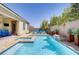Beautiful pool with a spa, surrounded by a well-maintained patio, lush greenery, and comfortable lounge chairs at 9779 Mosaic Canyon Ct, Las Vegas, NV 89149
