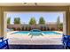 Relaxing backyard pool area with a beautiful pool, patio, and lush landscaping framed by an open porch at 9779 Mosaic Canyon Ct, Las Vegas, NV 89149