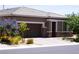 Inviting single-story home showcasing a two-car garage, desert landscaping, and pops of color from blooming plants at 10262 Havasu Falls St, Las Vegas, NV 89141