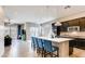 Open-concept kitchen featuring an island with seating, pendant lighting, and modern appliances with dark cabinets at 10262 Havasu Falls St, Las Vegas, NV 89141