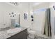 Well-lit bathroom with gray vanity and full tub and shower at 10951 Stone Crossing Ave, Las Vegas, NV 89166