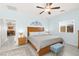 Spacious bedroom featuring a large bed, ceiling fan, and view into the dining room at 10951 Stone Crossing Ave, Las Vegas, NV 89166