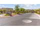 Entrance to Tribute Community Featuring Stone Sign, Gated Entry, and Well-Maintained Landscaping at 10951 Stone Crossing Ave, Las Vegas, NV 89166