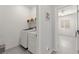 Well-lit laundry room with a new washer and dryer, convenient shelving, and easy access to other rooms at 10951 Stone Crossing Ave, Las Vegas, NV 89166